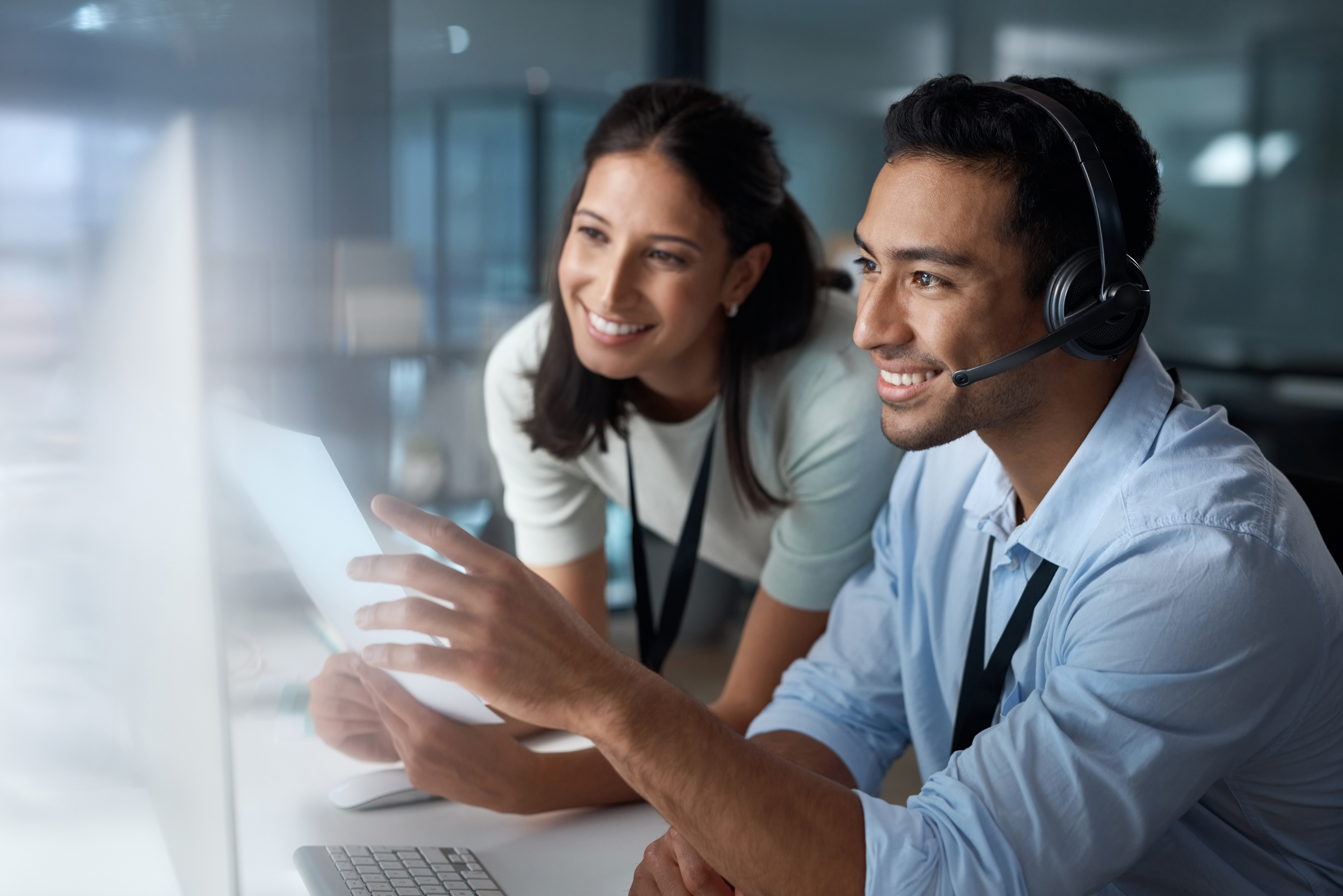 Customer care is more than a department, its an experience. Shot of a young man and woman using a computer while working in a call centre.